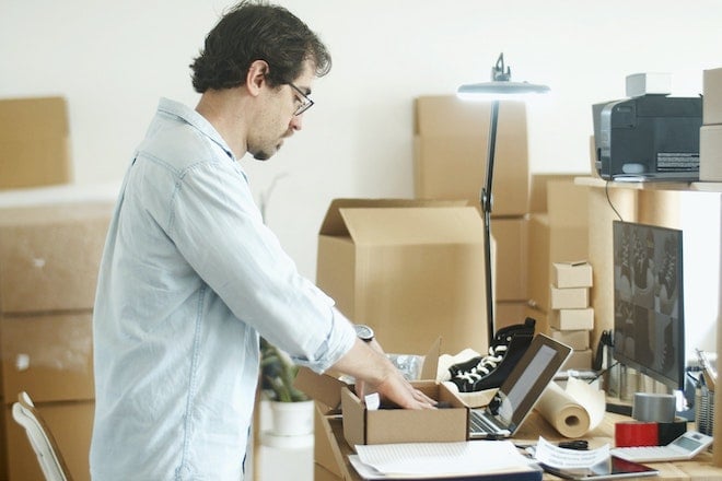 man putting items into boxes