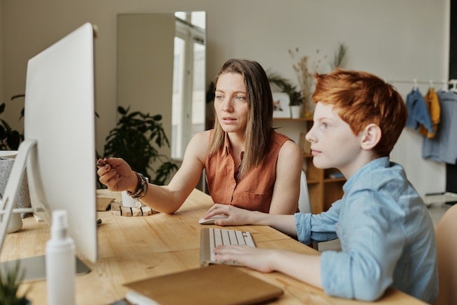 woman working with son at computer