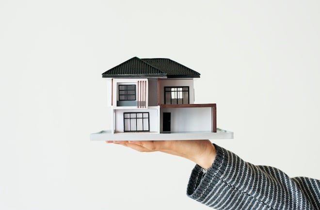 real estate house model in person's hand